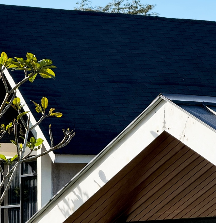 Toiture sombre d’une maison avec avancée de toit et bardage en bois